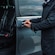 A driver opening the door of a private minibus